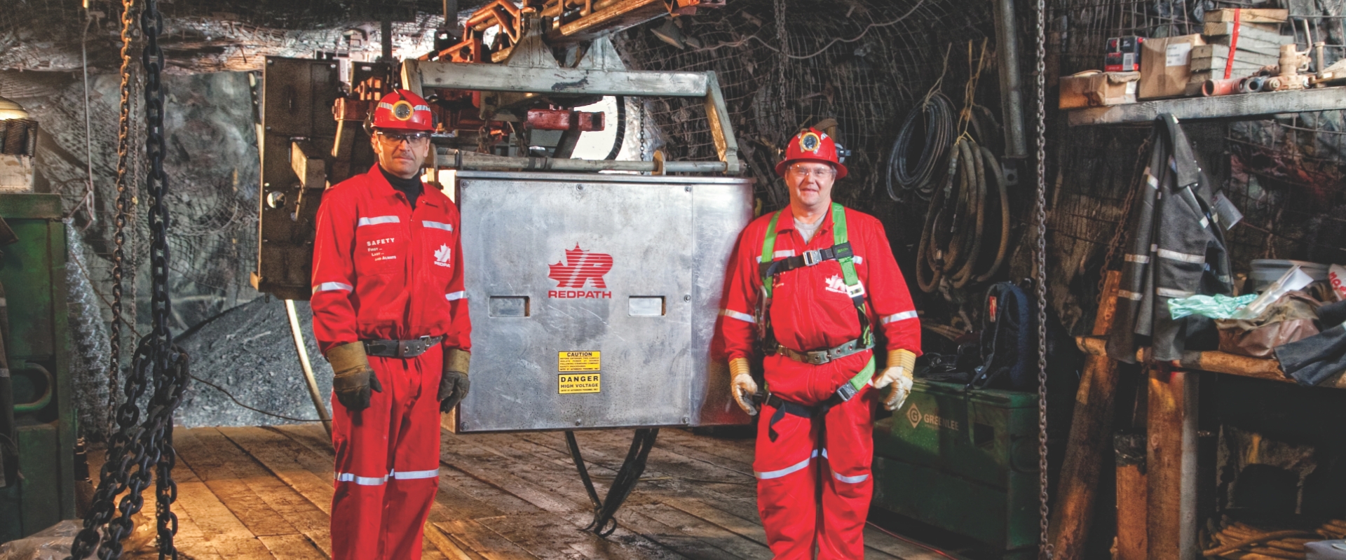 Deux employés de Redpath, vêtus d’un équipement de sécurité, effectuent des réparations internes sur une monture mécanisée.